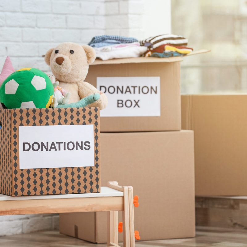 Donation,Boxes,With,Toys,And,Clothes,Indoors